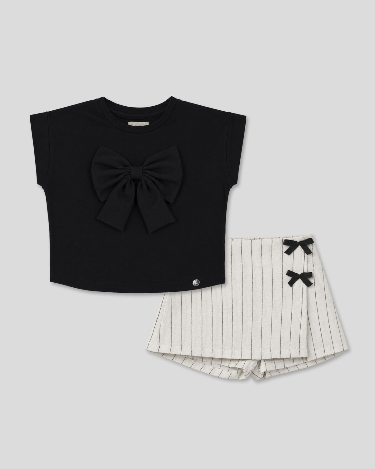 Conjunto blusa negra con moño y falda short en lino con rayas y moñitos para niña