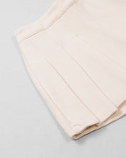 Conjunto blusa blanca con estampado y moño y falda short crema para niña