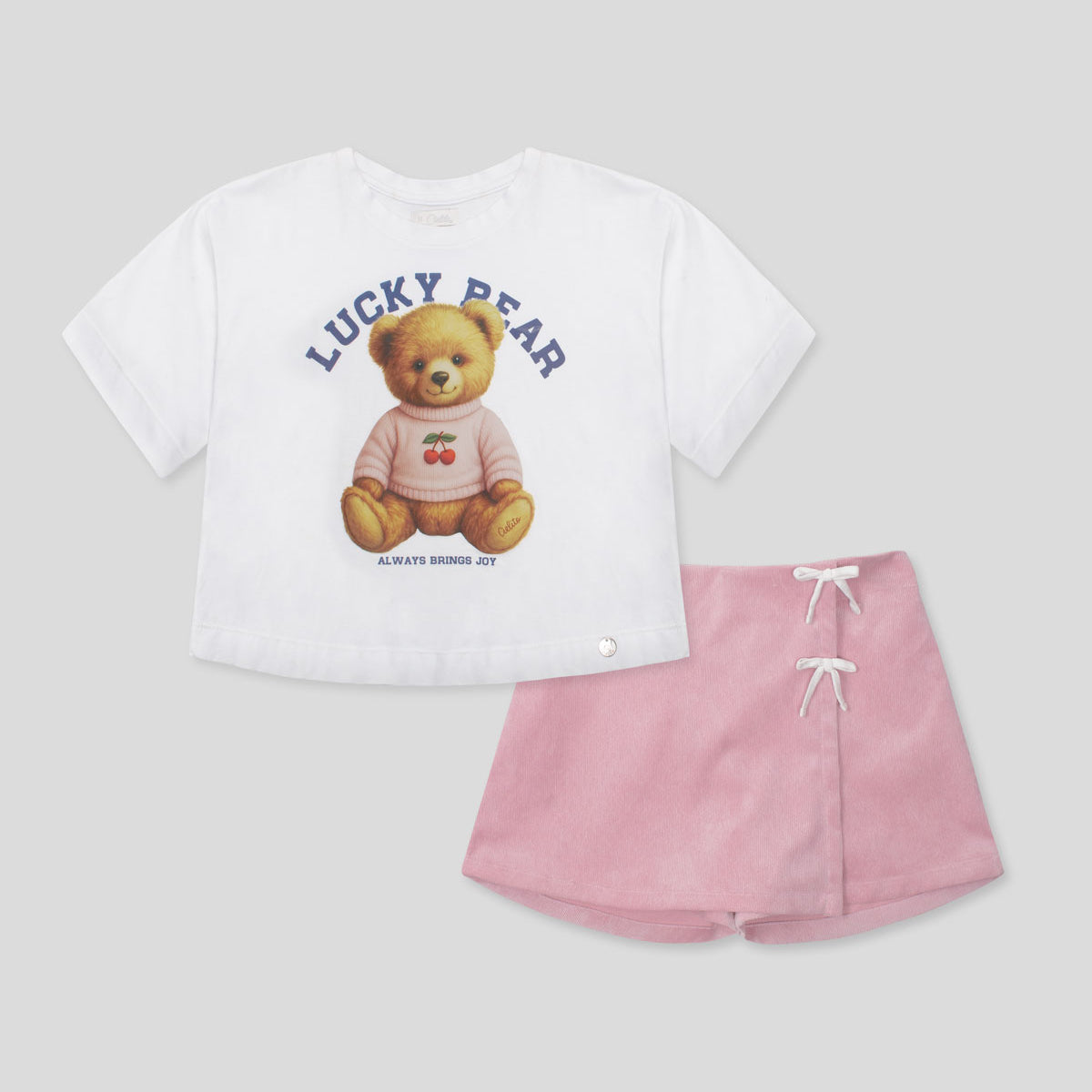 Conjunto blusa blanca con estampado de osita y falda short rosa con moñitos para niña