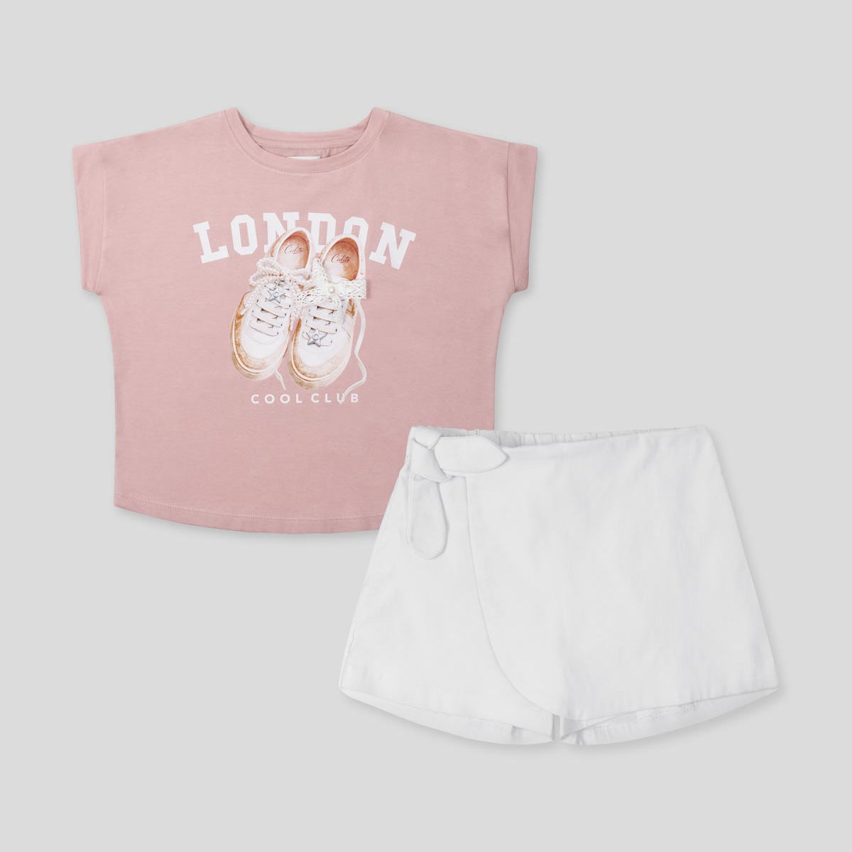 Conjunto camisa rosa estampada y falda short blanca para niña