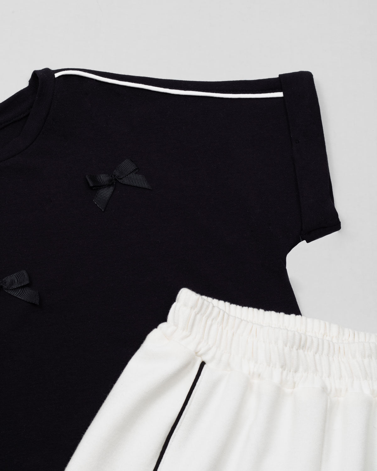 Conjunto blusa negra con moñitos y pantalón blanco para niña