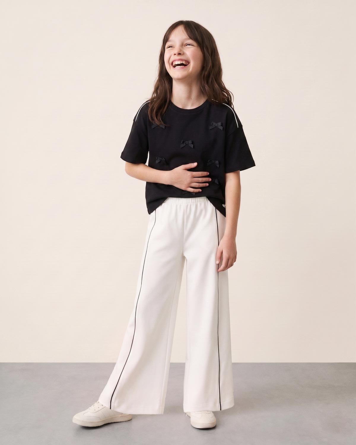 Conjunto blusa negra con moñitos y pantalón blanco para niña