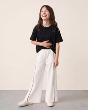 Conjunto blusa negra con moñitos y pantalón blanco para niña