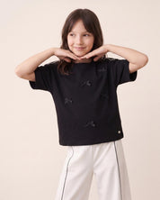 Conjunto blusa negra con moñitos y pantalón blanco para niña