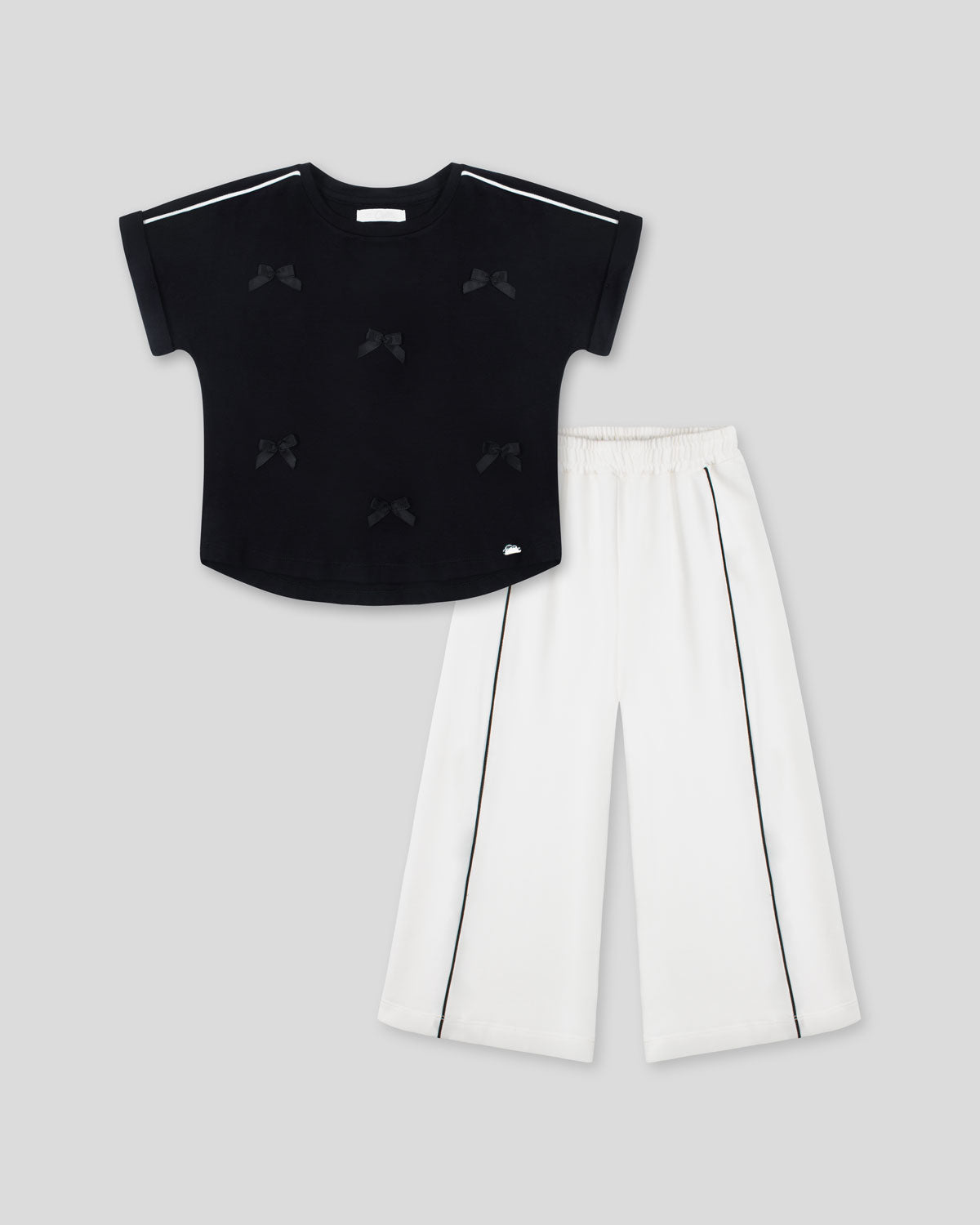 Conjunto blusa negra con moñitos y pantalón blanco para niña