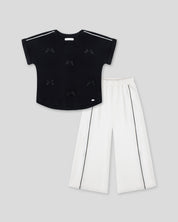 Conjunto blusa negra con moñitos y pantalón blanco para niña
