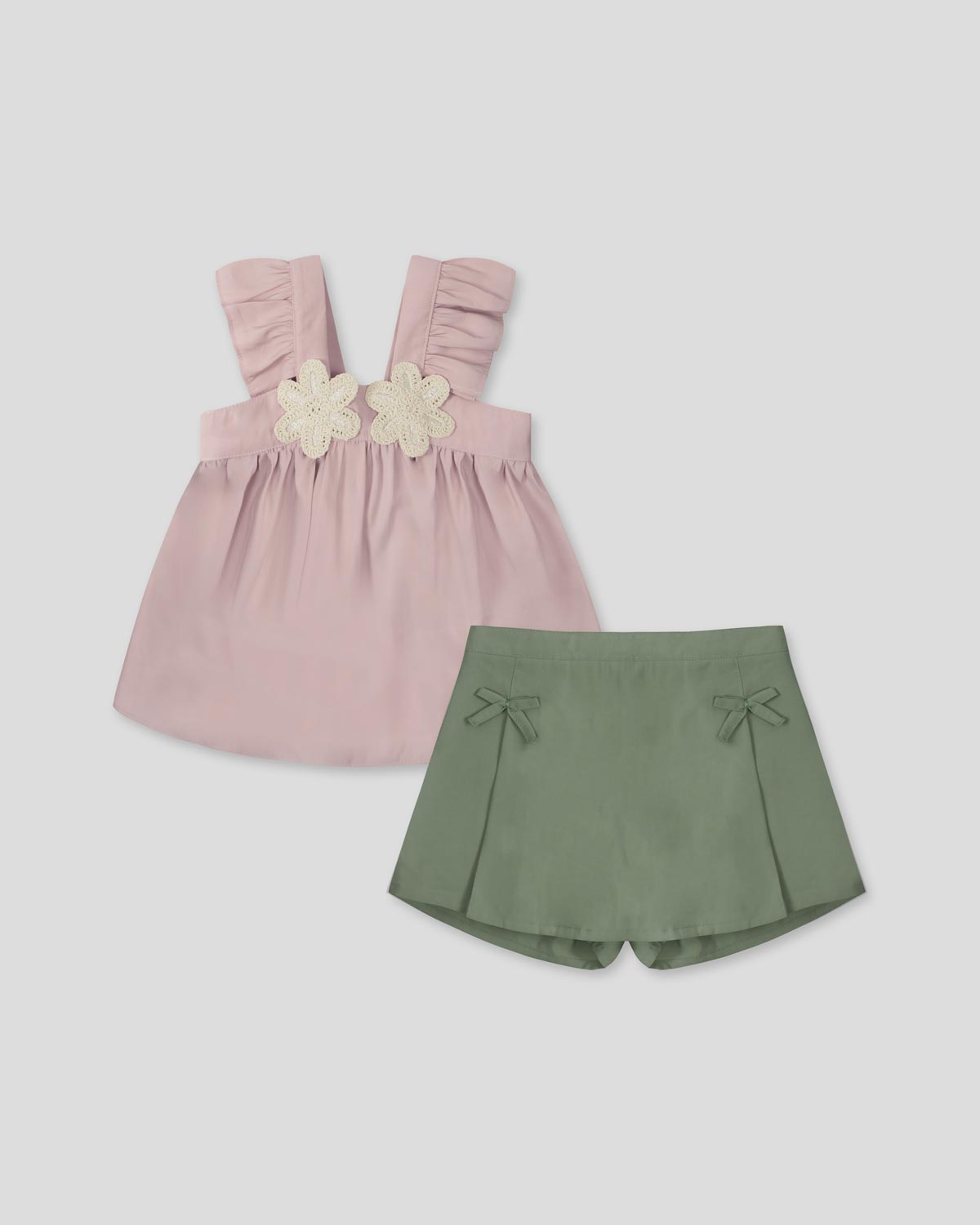 Conjunto blusa rosa de tiras con boleros, apliques de flor y falda short verde con moñitos para niña