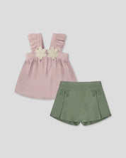 Conjunto blusa rosa de tiras con boleros, apliques de flor y falda short verde con moñitos para niña