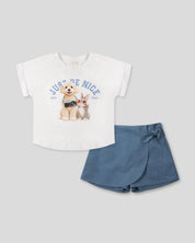 Conjunto camiseta blanca estampada Just Be Nice y falda short azul con moño para niña