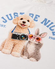 Conjunto camiseta blanca estampada Just Be Nice y falda short azul con moño para niña