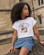 Conjunto camiseta blanca estampada Just Be Nice y falda short azul con moño para niña