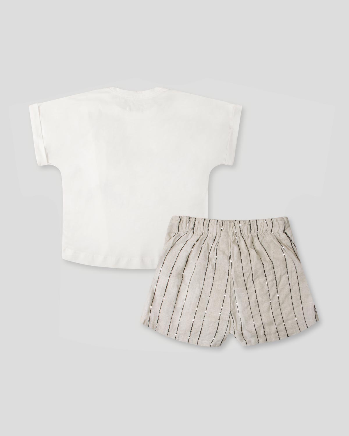 Conjunto camiseta blanca con moños y falda short beige con detalle de lentejuelas para niña