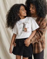 Conjunto blusa blanca con estampado de conejito y falda short negra con moño para niña