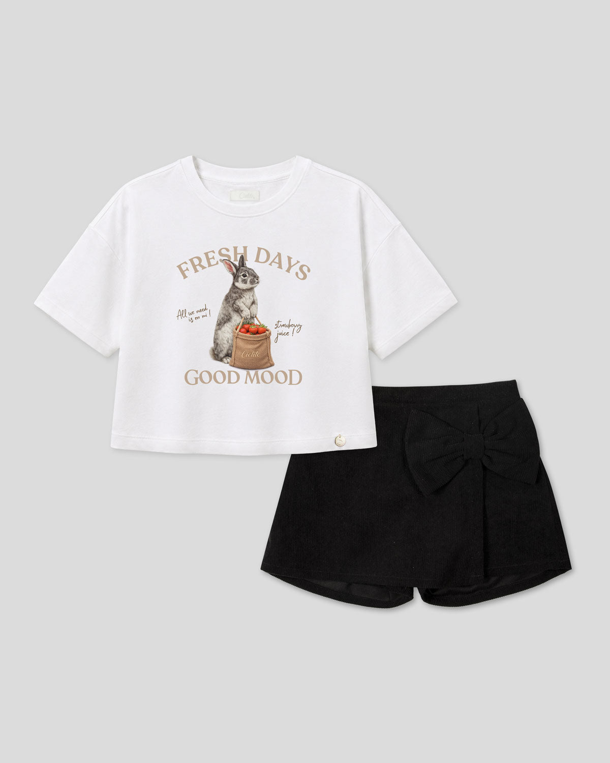 Conjunto blusa blanca con estampado de conejito y falda short negra con moño para niña