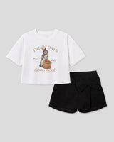 Conjunto blusa blanca con estampado de conejito y falda short negra con moño para niña
