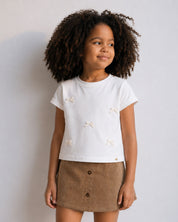 Conjunto camiseta blanca con moños y falda short café para niña