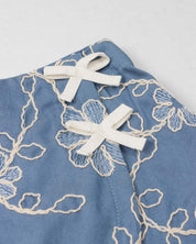 Conjunto blusa blanca y falda short azul con bordado de flores para niña