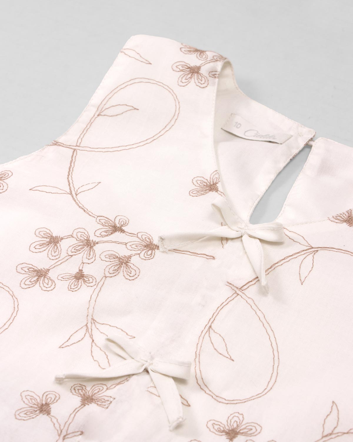 Conjunto blusa blanca con bordados de flores y falda short rosa con pliegues para niña
