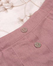 Conjunto blusa blanca con bordados de flores y falda short rosa con pliegues para niña