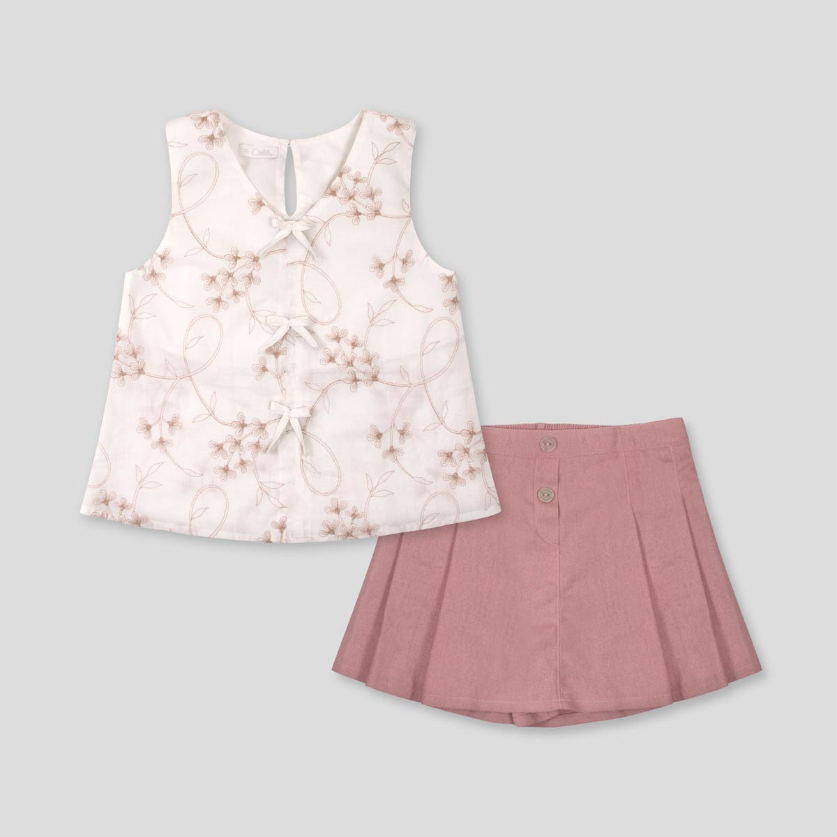 Conjunto blusa blanca con bordados de flores y falda short rosa con pliegues para niña