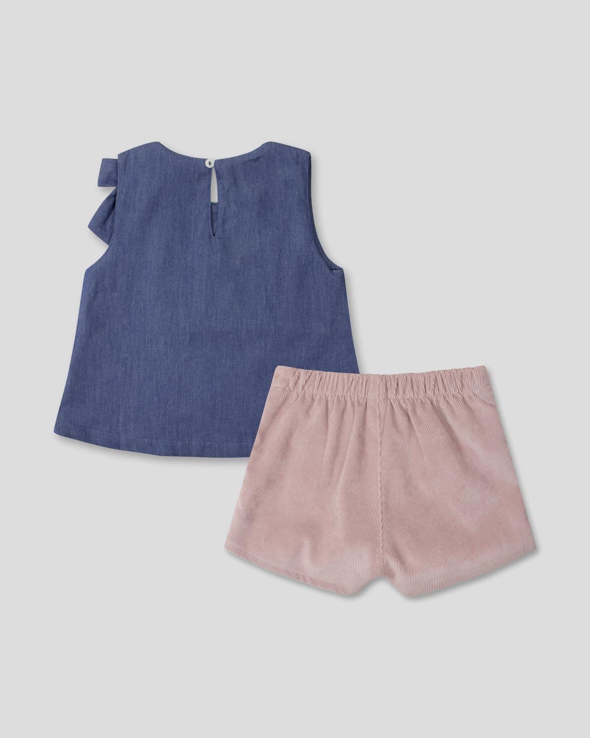 Conjunto blusa chambray con moño y falda short rosa con pliegues para niña