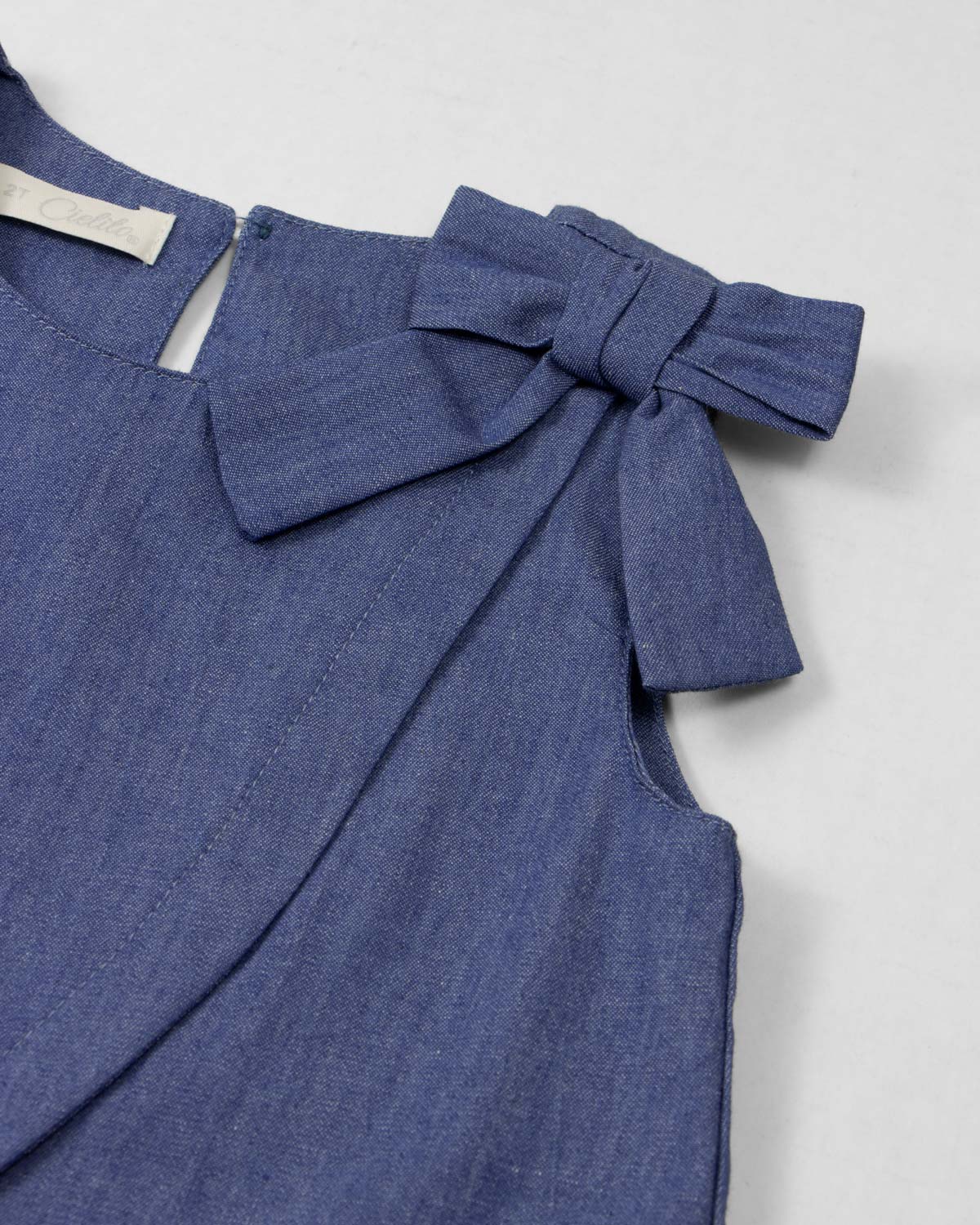 Conjunto blusa chambray con moño y falda short rosa con pliegues para niña