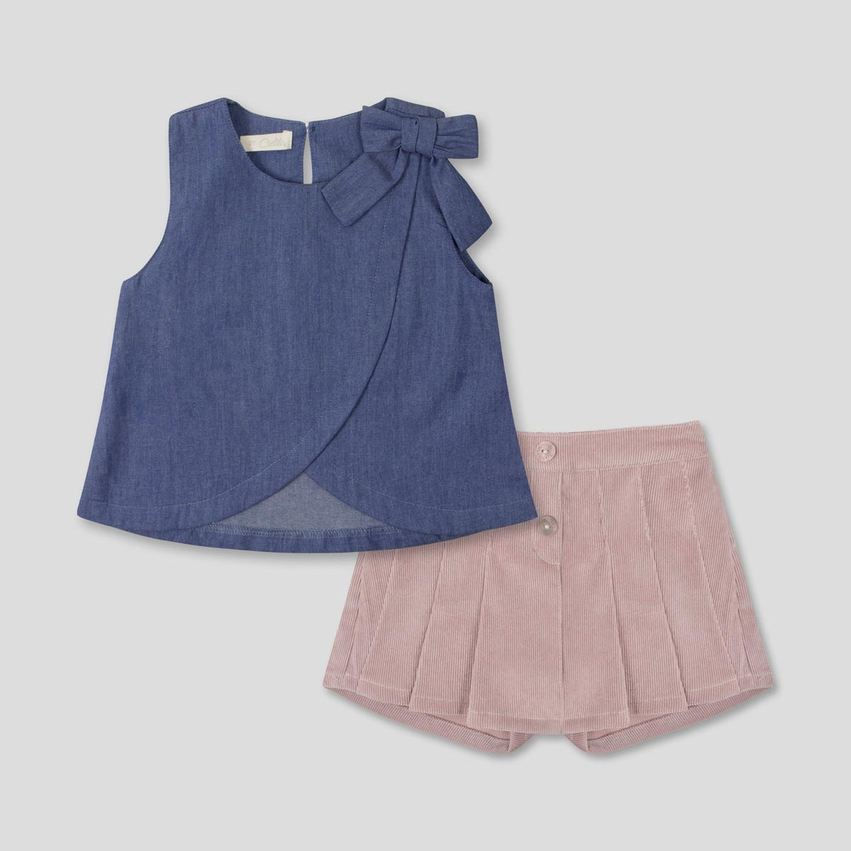 Conjunto blusa chambray con moño y falda short rosa con pliegues para niña