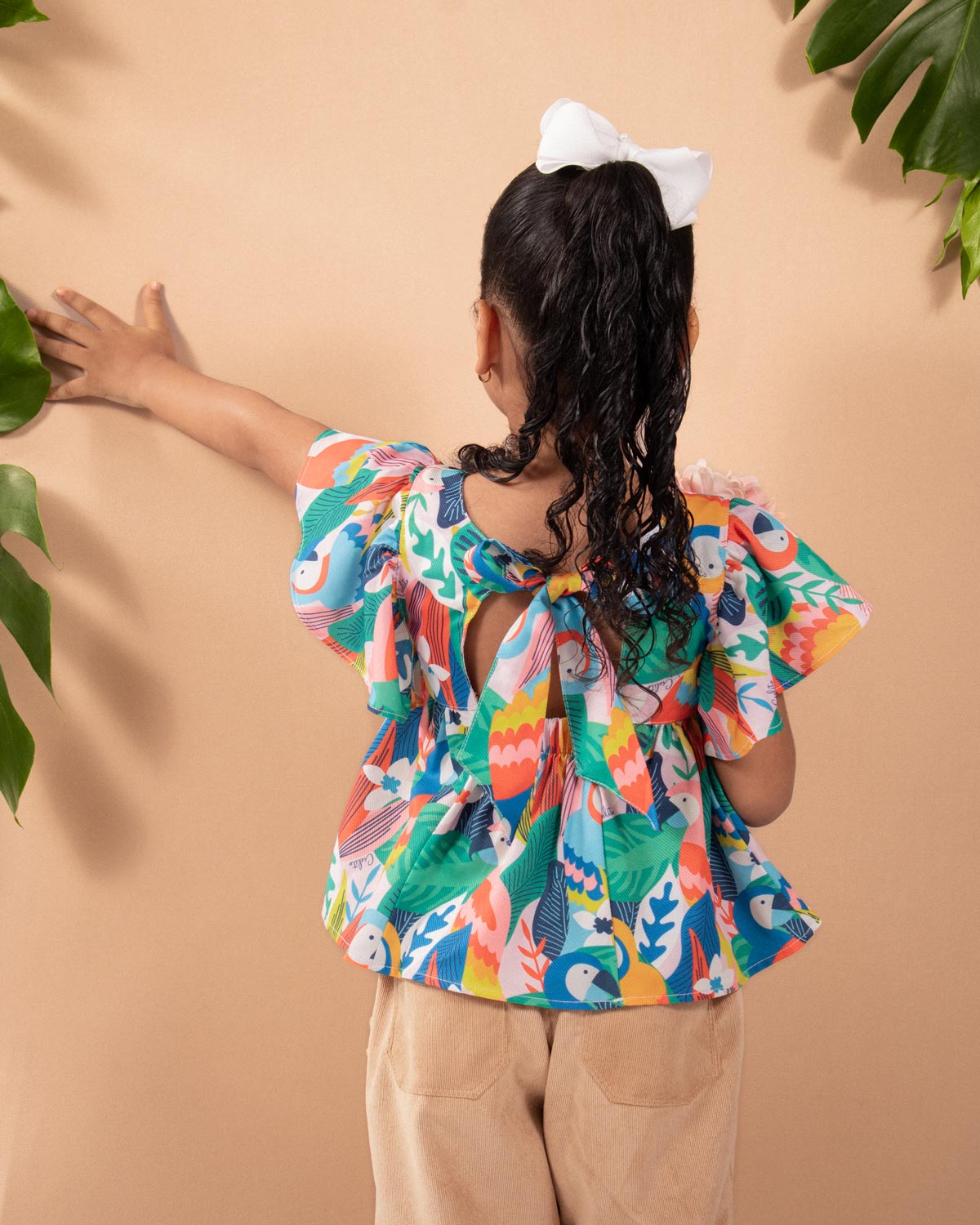 Blusa estampada de loritos con boleros y moño en espalda para niña