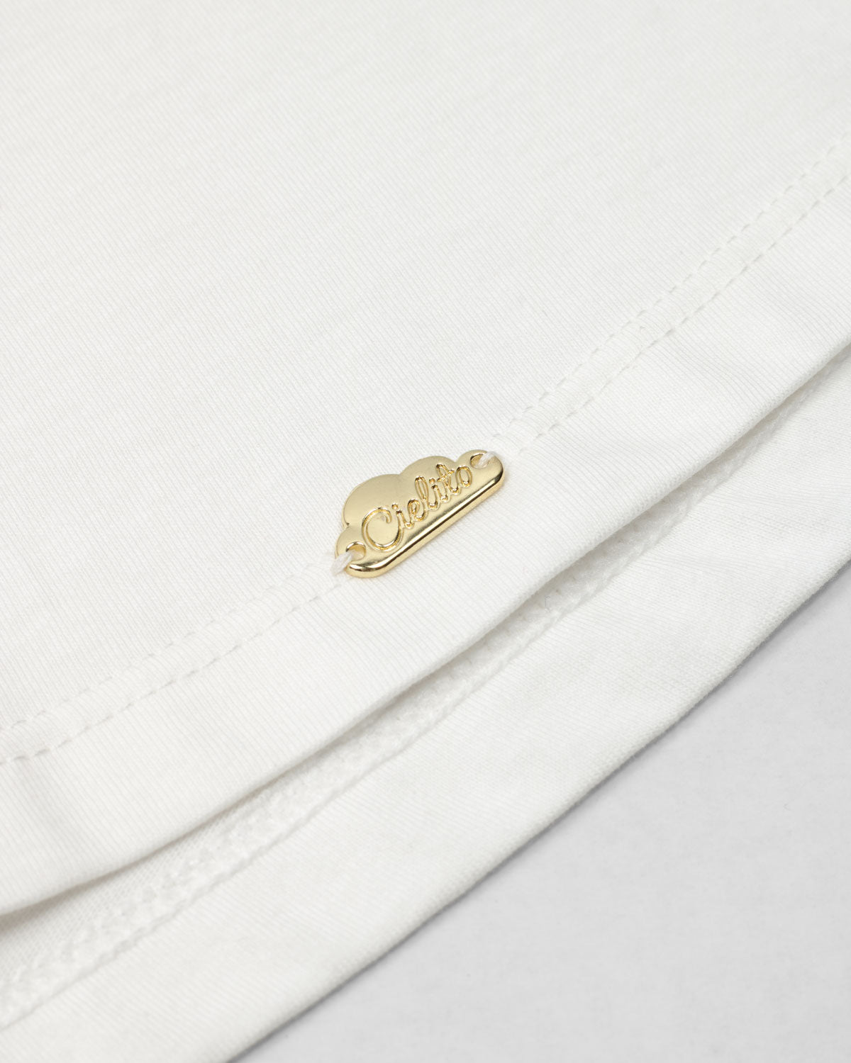 Camiseta con aplique moño en negro y estampado en cuello para niña