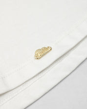 Camiseta con aplique moño en negro y estampado en cuello para niña