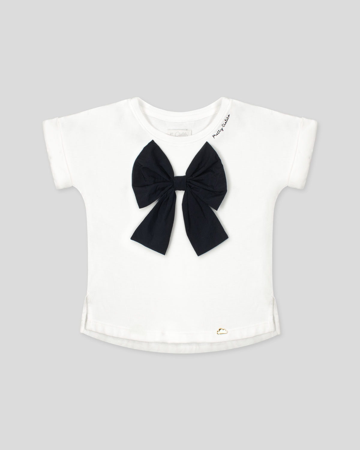 Camiseta con aplique moño en negro y estampado en cuello para niña