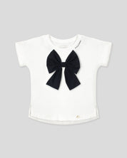 Camiseta con aplique moño en negro y estampado en cuello para niña