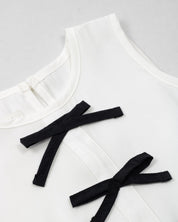 Blusa blanca con moñitos negros y bolero para niña