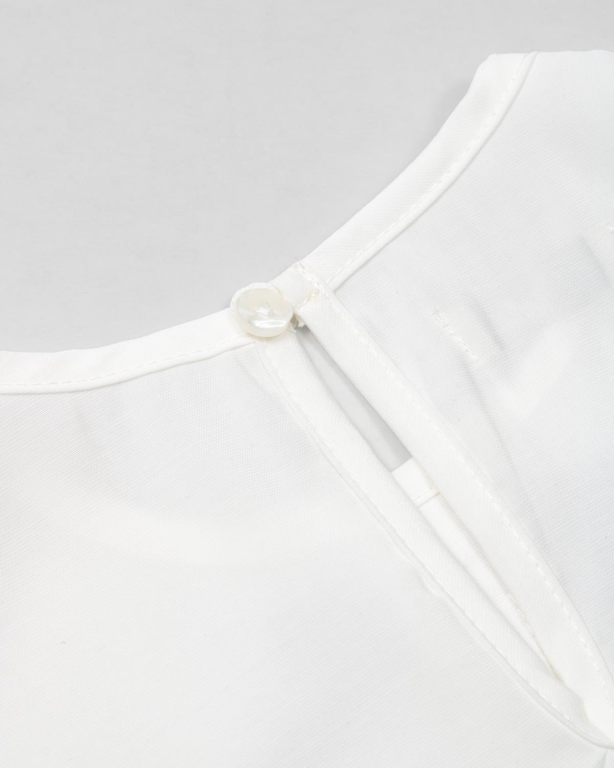 Blusa blanca con moñitos negros y bolero para niña