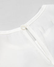 Blusa blanca con moñitos negros y bolero para niña