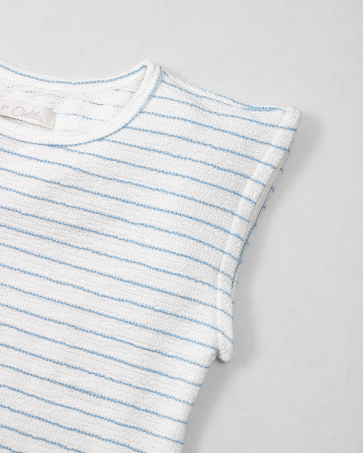Blusa blanca de rayas azules sin mangas para niña