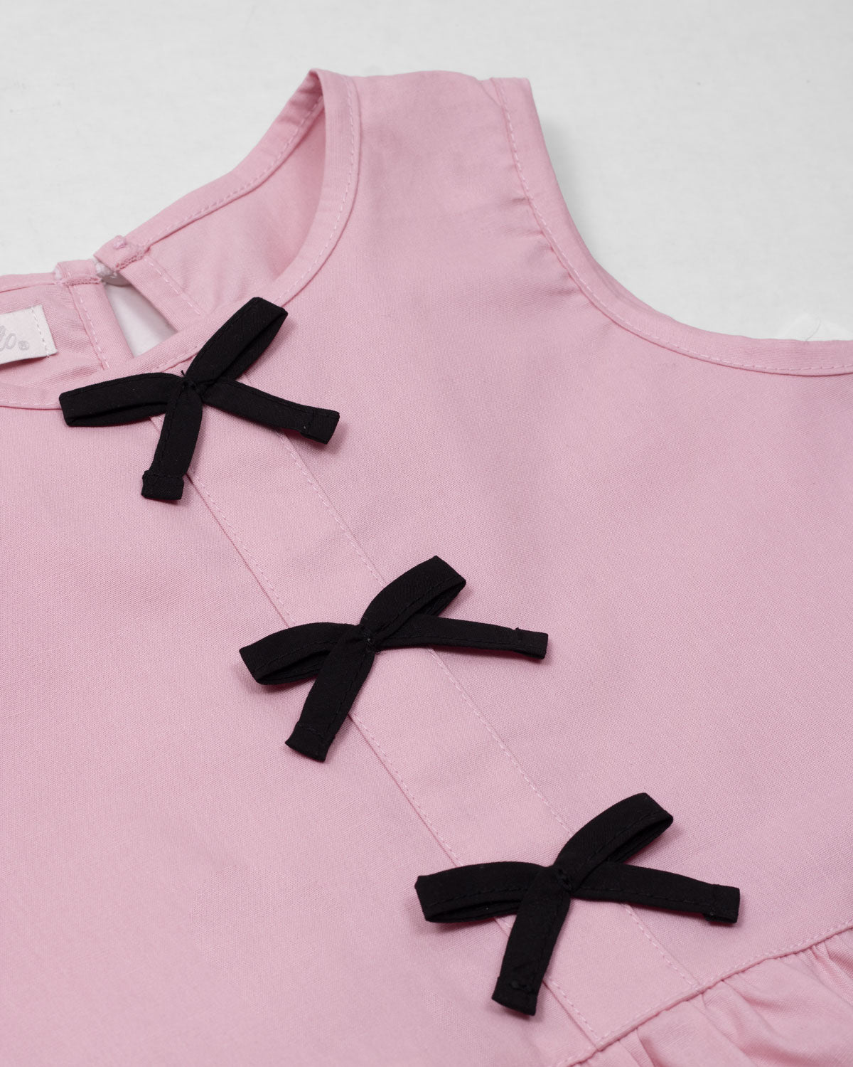 Blusa rosa con moños negros para niña