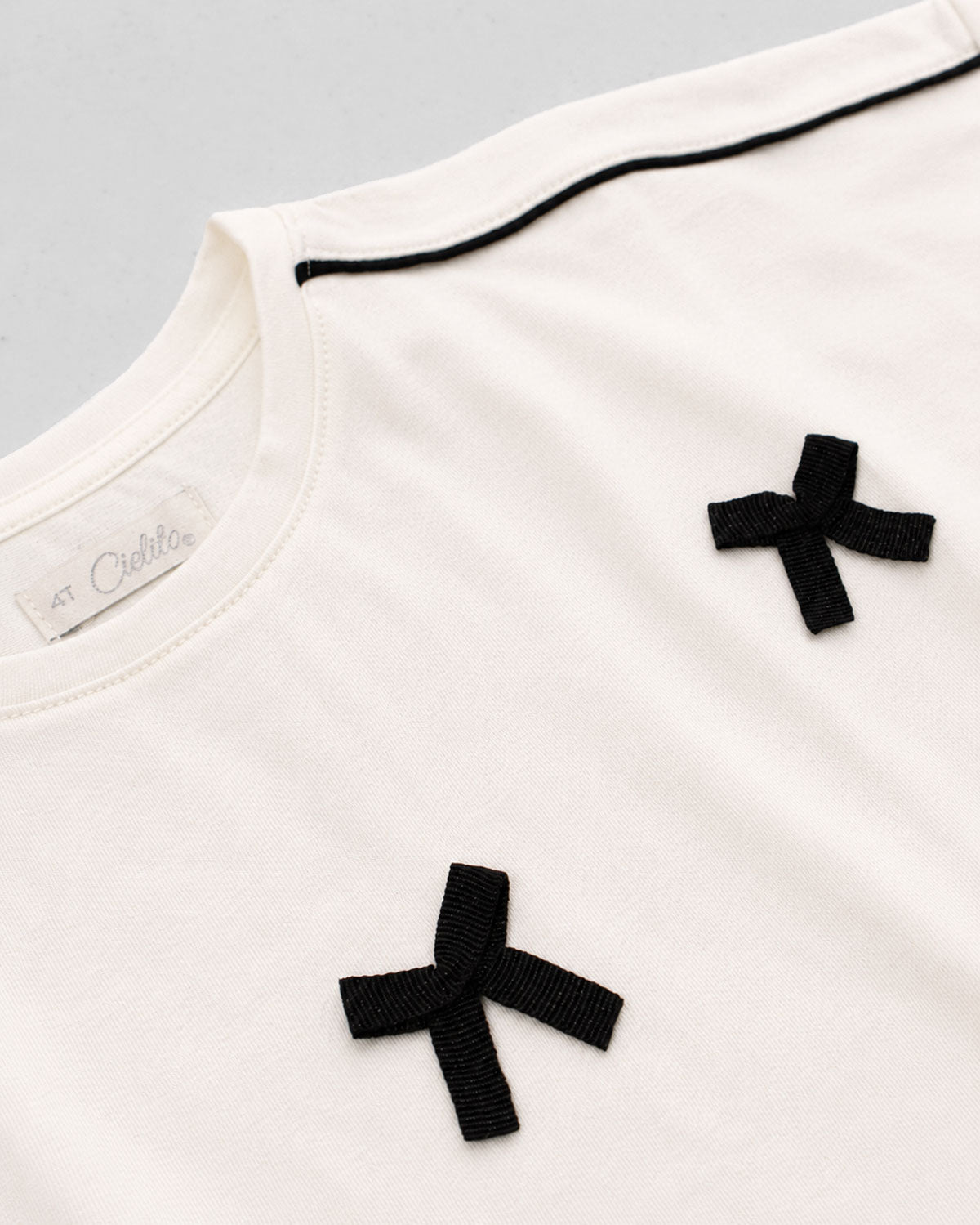Blusa blanca con moñitos para niña