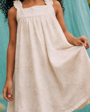 Vestido crema de tiras zurcidas con tela con bordado de flores y lentejuelas para niña