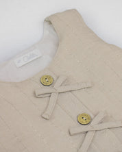 Blusa beige con botones y moñitos para niña