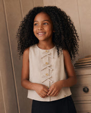 Blusa beige con botones y moñitos para niña