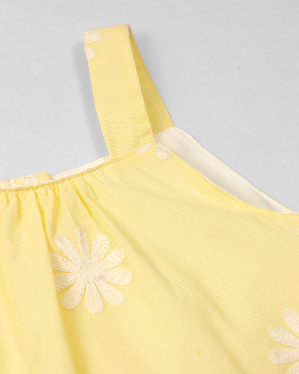 Blusa amarilla de tiras con bordados de flores y botonadura en espalda para niña