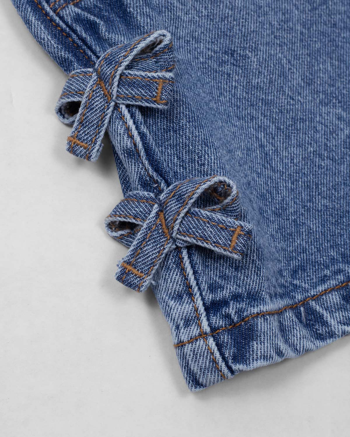 Short denim con moñitos en costados para niña