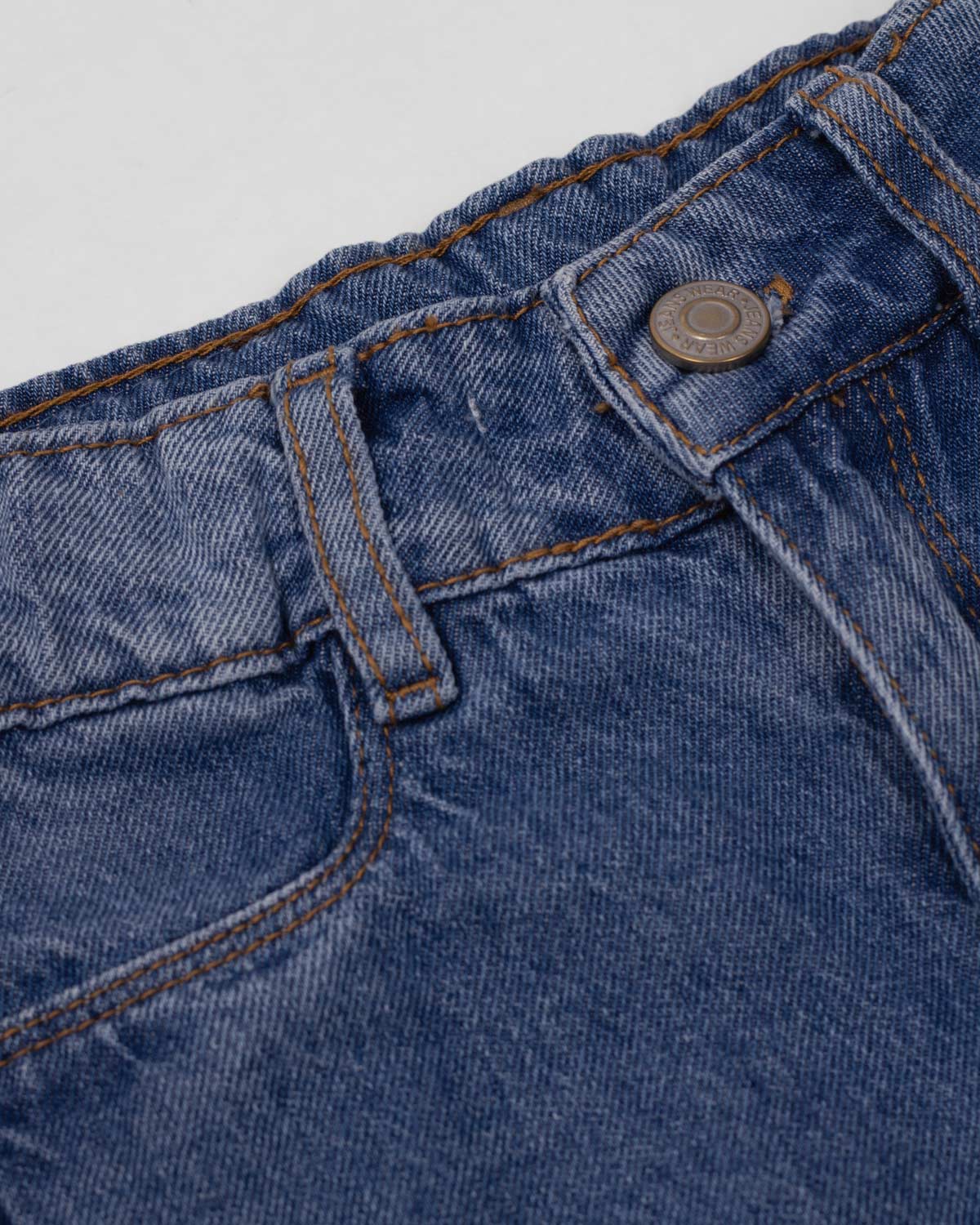Jean denim marine fit con detalle de moños en la bota para niña
