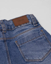 Jean denim marine fit con detalle de moños en la bota para niña