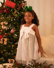 Vestido en satín blanco con moño y tull plisado con brillos plateados para niña