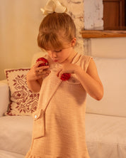 Vestido rosa terminado en bolero con tejido texturizado y bolsito pequeño para niña