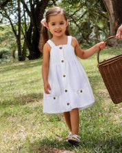 Vestido blanco de tiras con botonadura frontal y bolsillos para niña