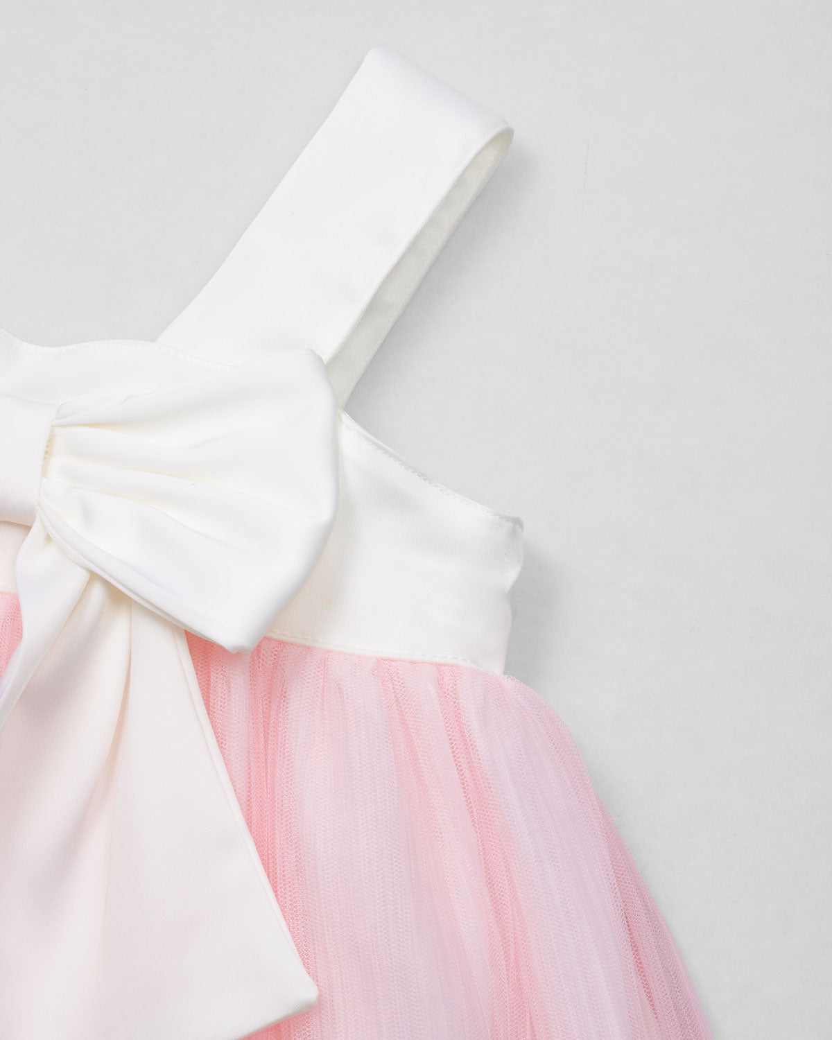 Vestido en satín blanco con moño y tull plisado rosa para niña