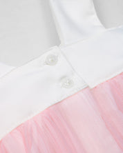Vestido en satín blanco con moño y tull plisado rosa para niña